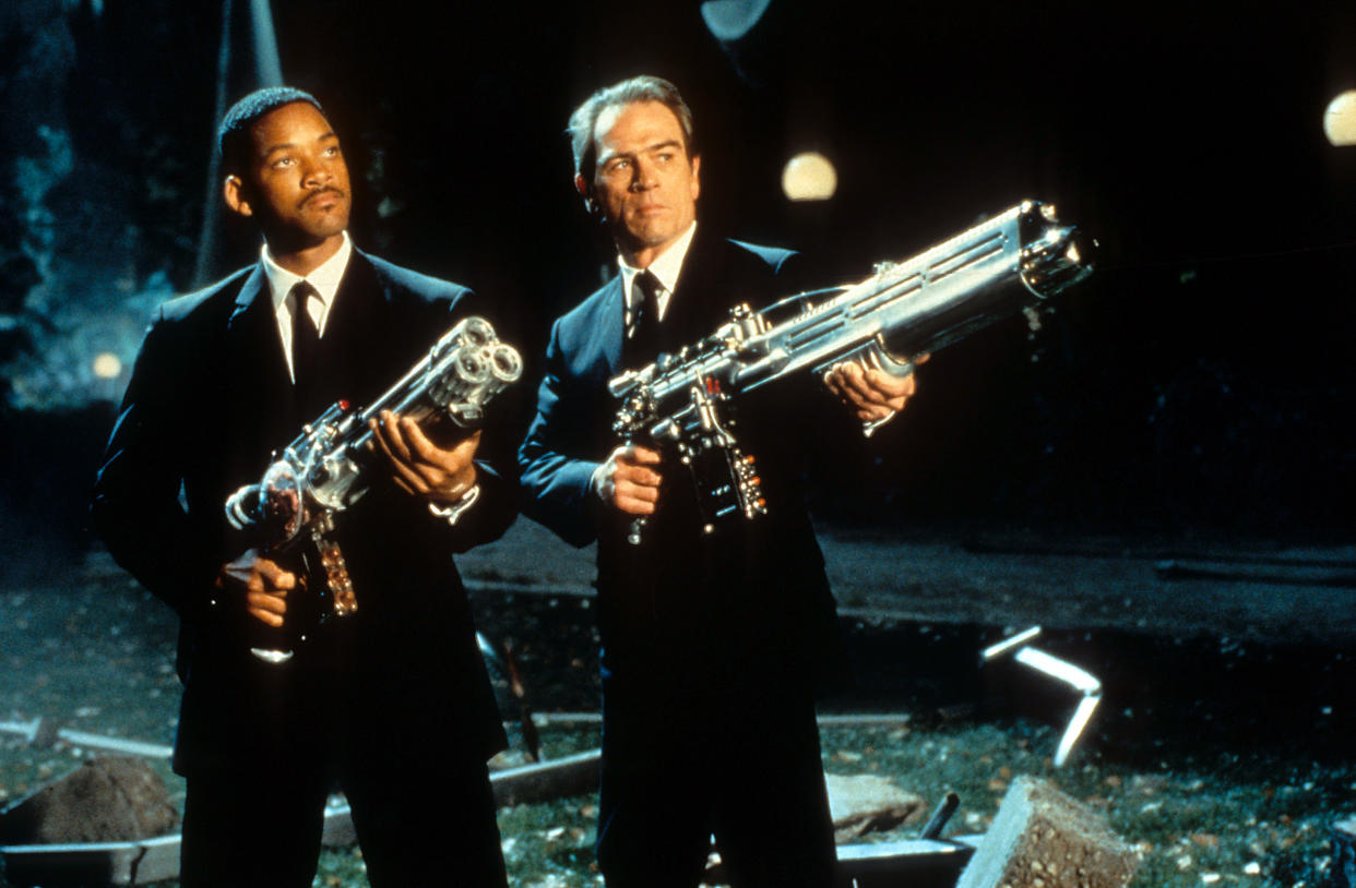 Will Smith y Tommy Lee Jones apuntando sus armas hacia el cielo en una escena de la película 'Hombres de Negro', 1997. (Foto de Columbia Pictures/Getty Images)