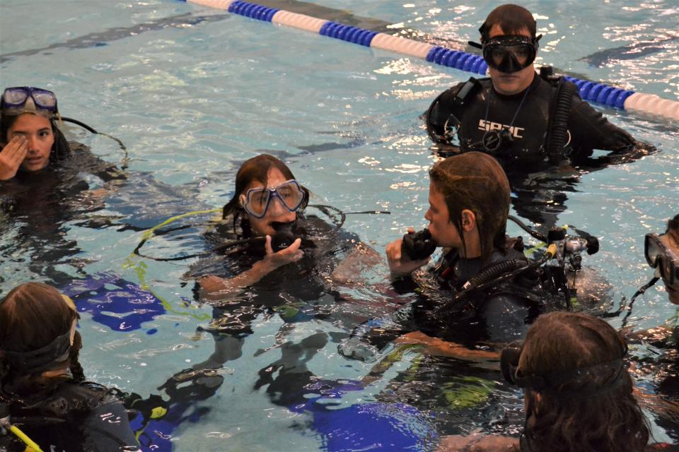 Students in a 'Coralition' intensive at Polaris Expeditionary Learning School take off their masks and regulators on Sept. 18 while working with instructors from the Colorado Scuba Diving Academy at Edora Pool Ice Center in Fort Collins.