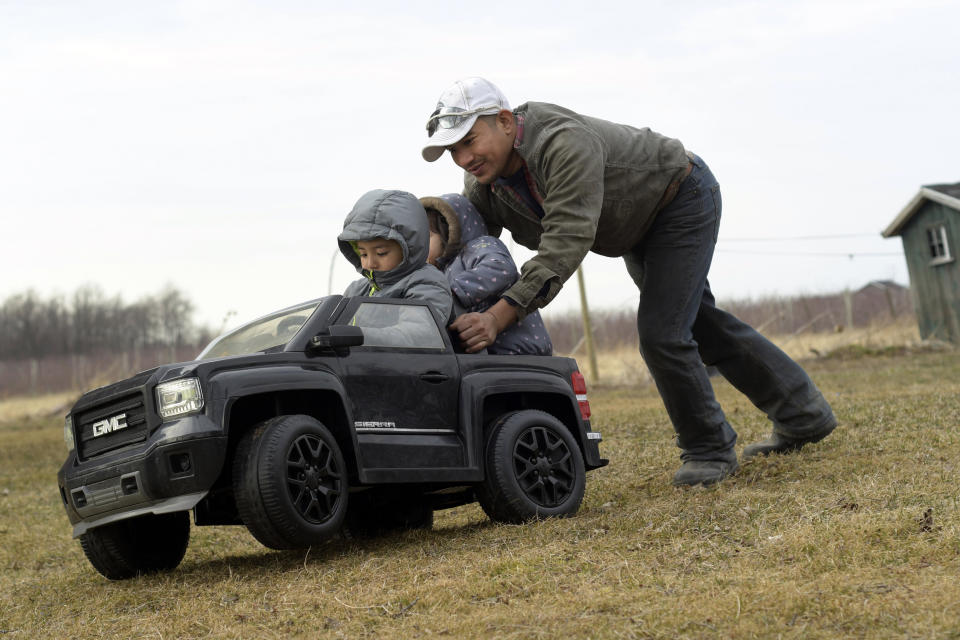 Eladio Beltran, right, pushes his children in a car at their home in Albion, New York. Beltran faces deportation because he was arrested for driving without a license. He is one of the many undocumented workers hoping to benefit from the "Green Light" bill. (Photo: Heather Ainsworth/AP Photo)