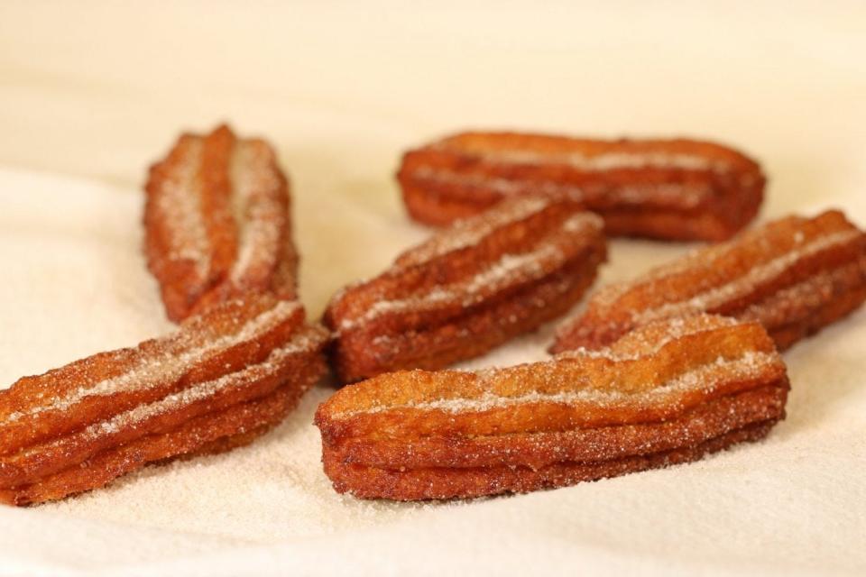 Fried churros dipped in cinnamon 
