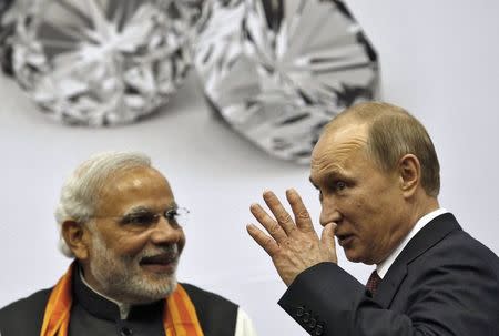 Russian President Vladimir Putin (R) gestures as India's Prime Minister Narendra Modi watches during the inauguration of World Diamond Conference in New Delhi December 11, 2014. REUTERS/Ahmad Masood