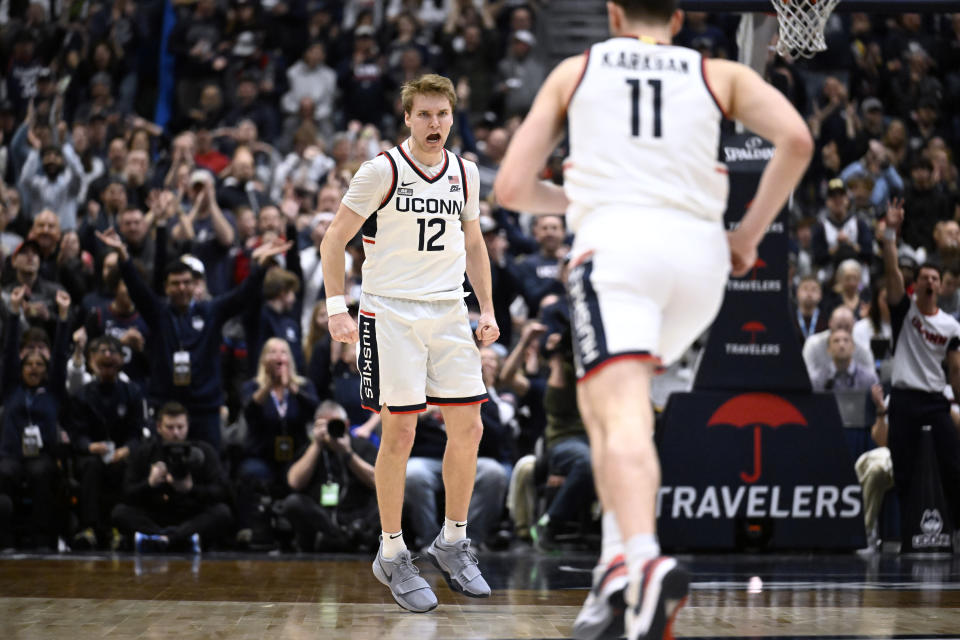 UConn guard Cam Spencer (12) reacts toward UConn forward Alex Karaban (11) in the first half of an NCAA college basketball game against Marquette, Saturday, Feb. 17, 2024, in Hartford, Conn. (AP Photo/Jessica Hill)