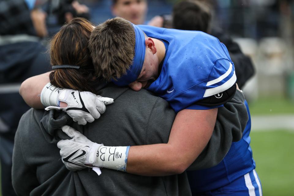 Falcons' Garrett Vance embraces a woman after winning the OHSAA Division IV State Final game between the Clinton-Massie Falcons and the Ursuline Fighting Irish at the Tom Benson Hall of Fame Stadium on Friday, Dec. 3, 2021. The Clinton-Massie Falcons won the game with a final score of 29-28.