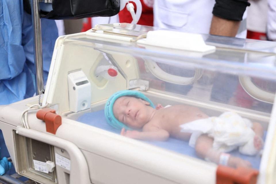 2023年11月20日，加薩與埃及之間的拉法關卡，醫護人員將希法醫院的早產兒送往埃及這一側的救護車。路透社