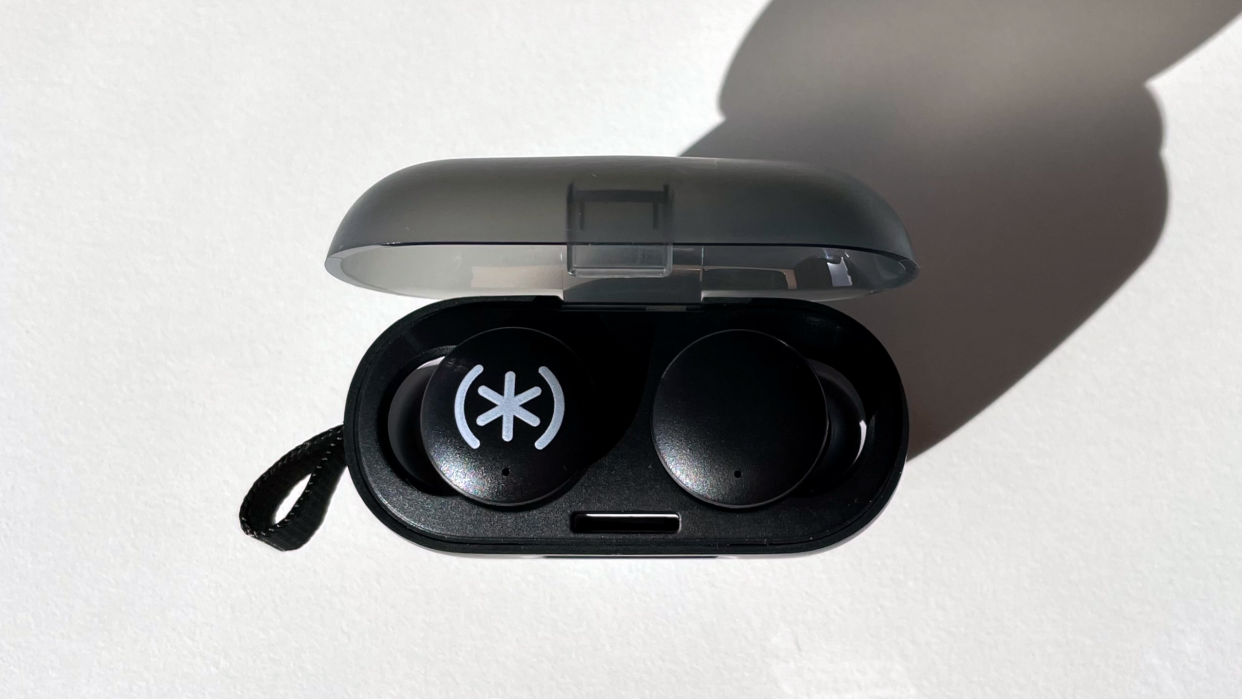  A view from directly above the Speck Gemtones Play earbuds are shown sitting in their charging case sitting on a white table top. 