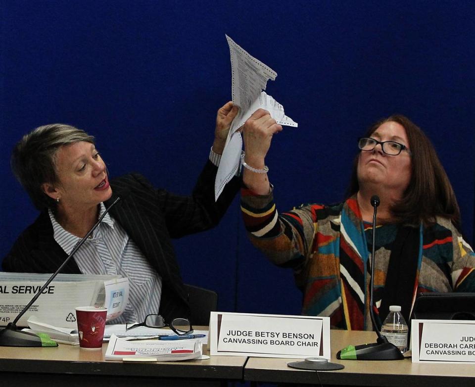 Judge Betsy Benson, canvassing board chair, left, and Judge Deborah Carpenter-Toye, canvassing board member, examine a damaged ballot as the election recount continues in Broward County on Wednesday, Nov. 14, 2018.