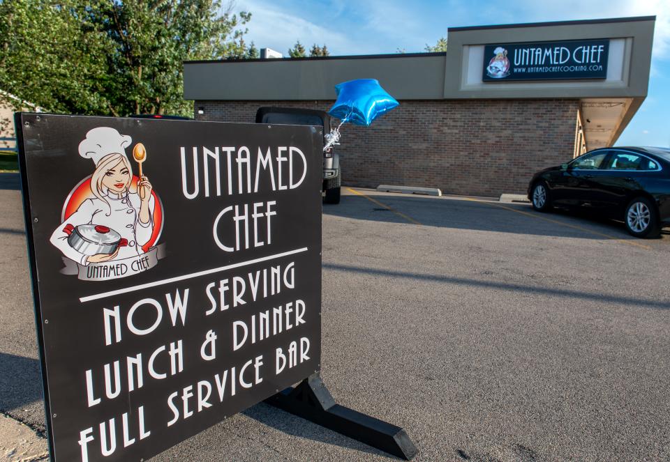 A sign advertises the new dining service and bar now open at the Untamed Chef, 7338 N University St., in Peoria.