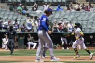 Oakland Athletics' Shea Langeliers, right, runs the bases after hitting a two-run home run off of Texas Rangers pitcher Michael Lorenzen, foreground, during the second inning in the first baseball game of a doubleheader Wednesday, May 8, 2024, in Oakland, Calif. (AP Photo/Godofredo A. Vásquez)