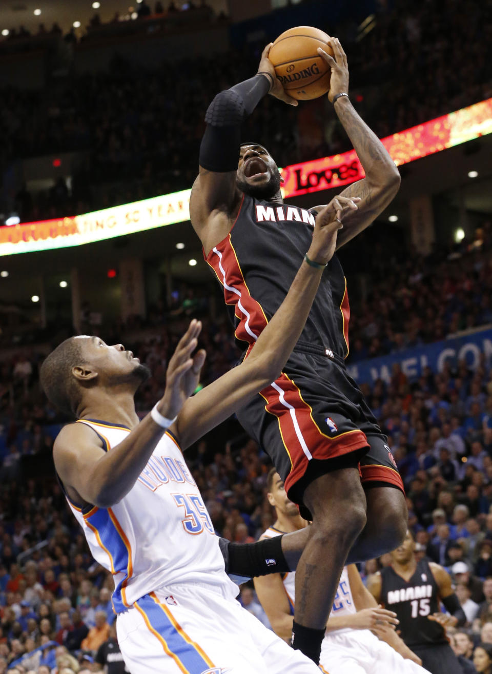 Miami Heat forward LeBron James (6) is fouled by Oklahoma City Thunder forward Kevin Durant (35) during tthe first quarter of an NBA basketball game in Oklahoma City, Thursday, Feb. 20, 2014. (AP Photo/Sue Ogrocki)