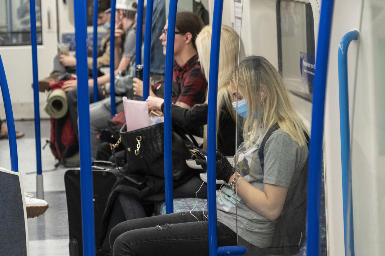  A woman wearing a face mask and gloves as a preventive measure seen on a tube train. The Government has made it mandatory to wear face coverings on all public transport and in different places like shops, banks and post offices as well as shops, supermarkets, indoor shopping centres and stations in England today. (Photo by Edward Crawford / SOPA Images/Sipa USA) 