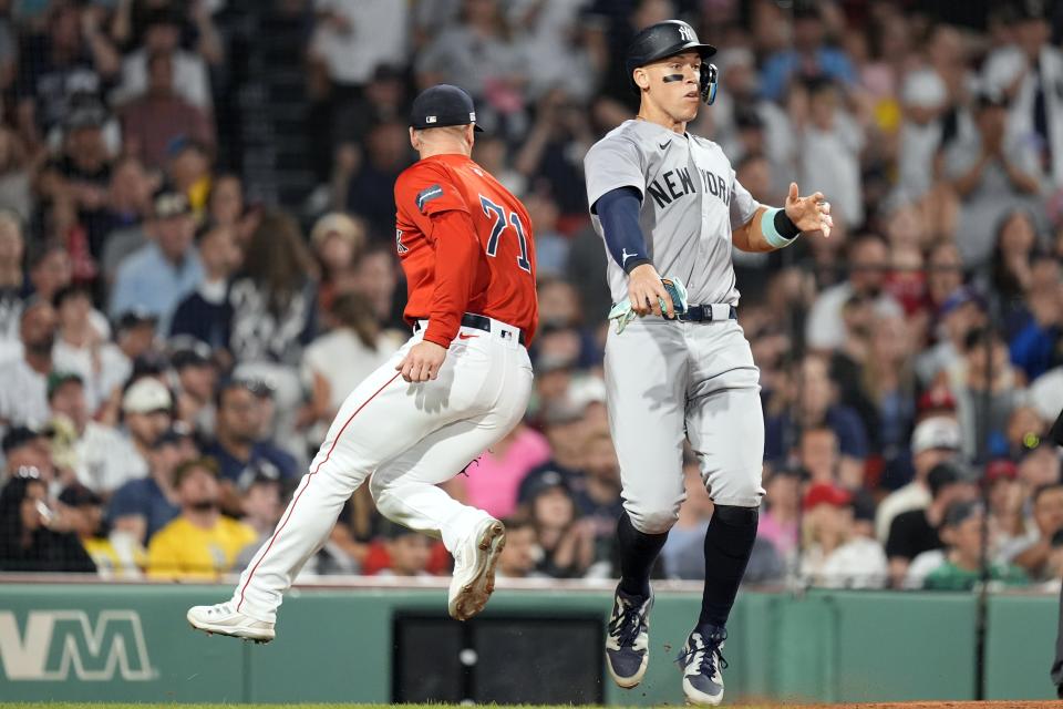 New York Yankees' Aaron Judge avoids Boston Red Sox relief pitcher Cam Booser (71), who was running to cover home plate, after scoring during the fifth inning of a baseball game, Friday, June 14, 2024, in Boston. (AP Photo/Michael Dwyer)