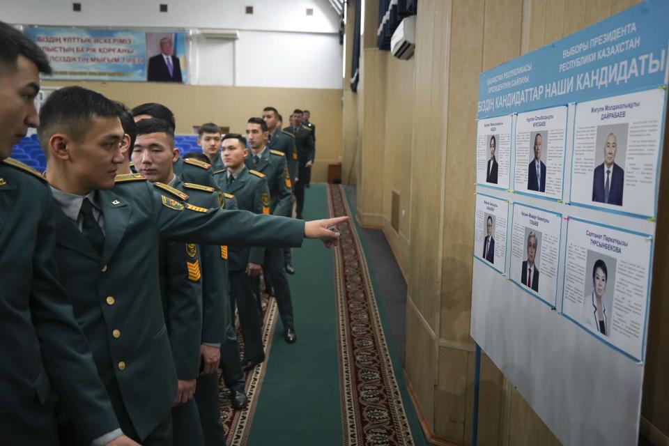 National servicemen lineup to cast their votes next to a poster showing presidential candidates at a polling station in Almaty, Kazakhstan, Sunday, Nov. 20, 2022. Kazakhstan's president appears certain to win a new term against little-known challengers in a snap election on Sunday. Five candidates are on the ballot against President Kassym-Jomart Tokayev, who faced a bloody outburst of unrest early this year and then moved to marginalize some of the Central Asian country's longtime powerful figures. (Vladimir Tretyakov/NUR.KZ via AP)