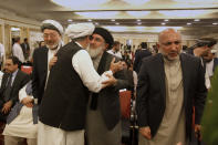 Afghan Warlord Gulbuddin Hekmatyar, leader of Islamist organization Hezb-i-Islami, center, hugs an Afghan politician while Haneef Atmar, right, and Mohammad Karim Khalili, left, looks on during an Afghan Peace Conference in Bhurban, 65 kilometers (40 miles) north of Islamabad, Pakistan, Saturday, June 22, 2019. Dozens of Afghan political leaders attended a peace conference in neighboring Pakistan on Saturday to pave the way for further Afghan-to-Afghan dialogue. (AP Photo/Anjum Naveed)