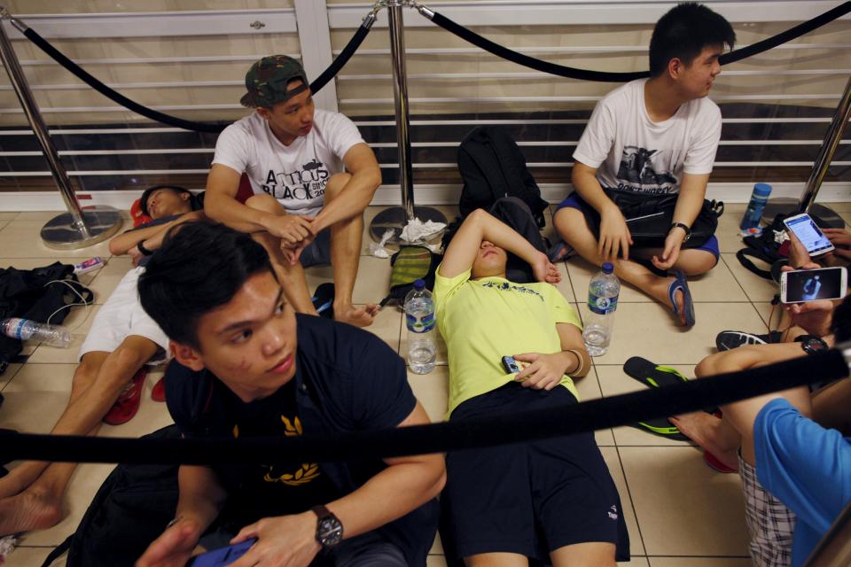 People sleep as they queue overnight for the launch of the new Apple iPhone 6s mobile phone at a mall in Singapore