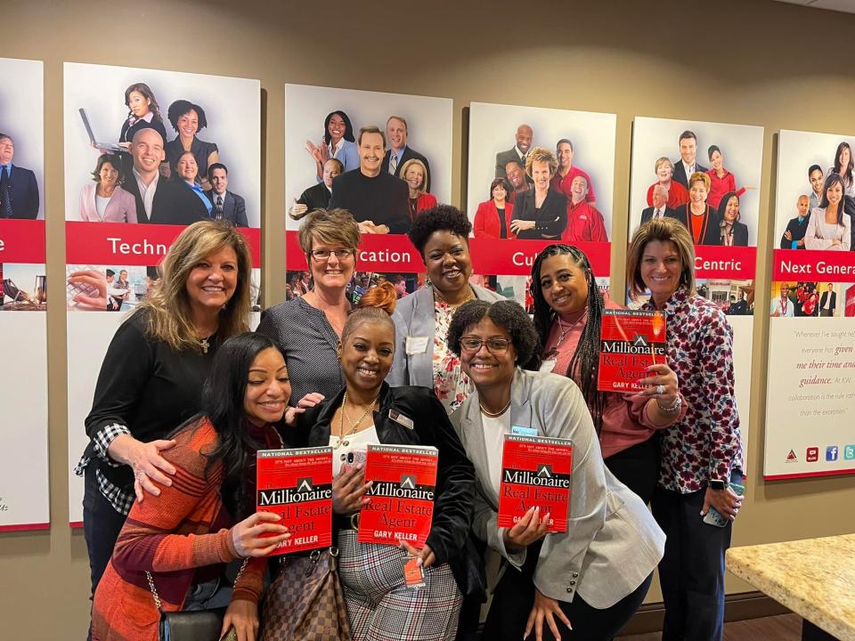 Staff with Keller Williams Indy Metro pose with a book written by Gary Keller. The agency was named a Top Workplace in The Indianapolis Star’s annual survey of Central Indiana workplaces. The results were tabulated by Energage, which surveyed employees.