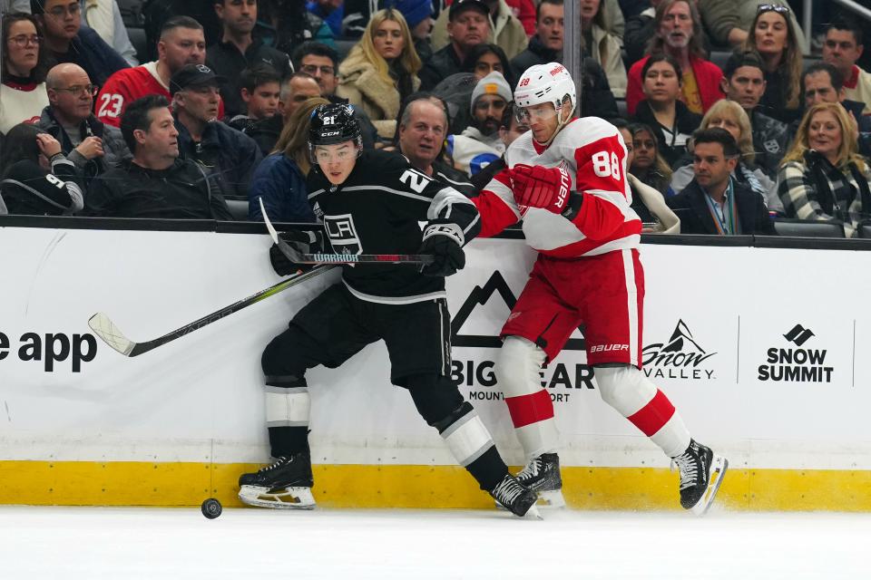 LA Kings defenseman Jordan Spence (21) and Detroit Red Wings right wing Patrick Kane (88) battle for the puck in the first period at Crypto.com Arena in Los Angeles on Thursday, Jan. 4, 2024.