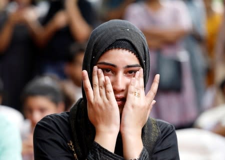 Kashmiri woman wipes her tears while listening to a story at a function where fellow compatriots gathered to observe Eid al-Adha in New Delhi