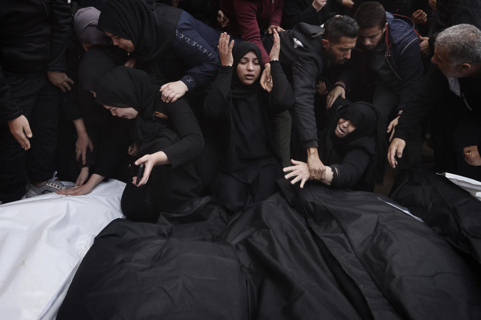 Palestinos lloran a sus familiares muertos en un bombardeo israelí en Gaza, en el exterior de una morgue de Jan Yunis, el 20 de diciembre de 2023. (AP Foto/Mohammed Dahman)