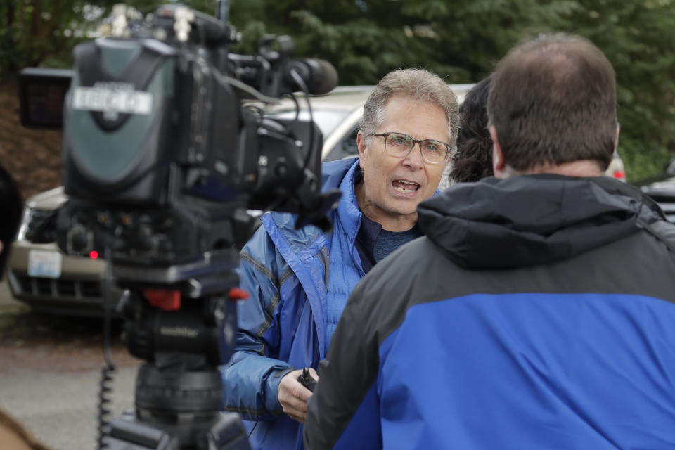 In this March 12, 2020, photo, Scott Sedlacek becomes animated as talks to reporters outside Life Care Center in Kirkland, Wash., near Seattle. The facility has been at the center of the coronavirus outbreak in the state, and Sedlacek — who also has tested positive for the virus — said he and his siblings have barely spoken to their father who lives inside the center, and in addition to testing positive for the coronavirus, has blindness, neuropathy, and has difficulty using a phone, saying he is more of an "inmate" than a patient. Residents of assisted living facilities and their loved ones are facing a grim situation as the coronavirus spreads across the country, placing elderly people especially at risk. (AP Photo/Ted S. Warren)