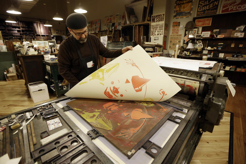 This Jan. 15, 2014 photo shows Jim Sherraden printing from an original wood block at Hatch Show Print in Nashville, Tenn. There’s no cost to watch the presses and the staff churn out the iconic handmade art that has been used by everyone from Grand Ole Opry stars to blues and jazz greats and modern rock bands. If you want to take some posters home, there is a large selection to choose from. (AP Photo/Mark Humphrey)