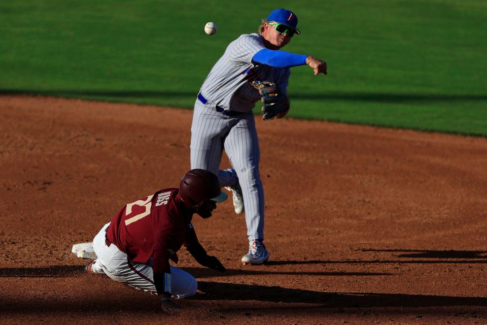 Florida infielder Dale Thomas (1) turns the double play on Florida St. outfielder DeAmez Ross (27) at second base during the teams' May 2023 meeting in Jacksonville.