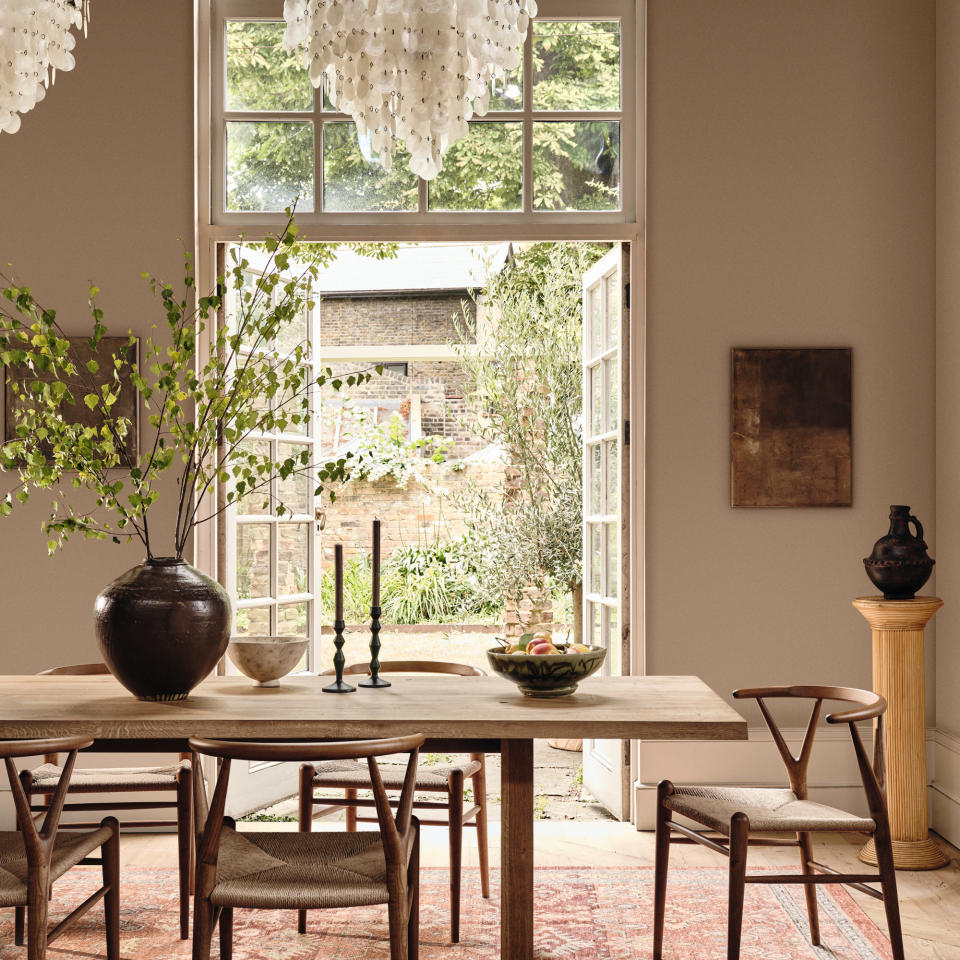 Neutral painted living and dining room opening up to tall window