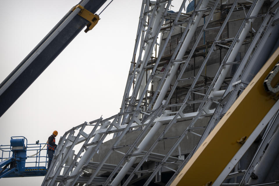 A worker stands on an electric lift as he works at a construction site in Beijing, Wednesday, Oct. 12, 2022. A meeting of the ruling Communist Party to install leaders gives President Xi Jinping, China's most influential figure in decades, a chance to stack the ranks with allies who share his vision of intensifying pervasive control over entrepreneurs and technology development. (AP Photo/Mark Schiefelbein)