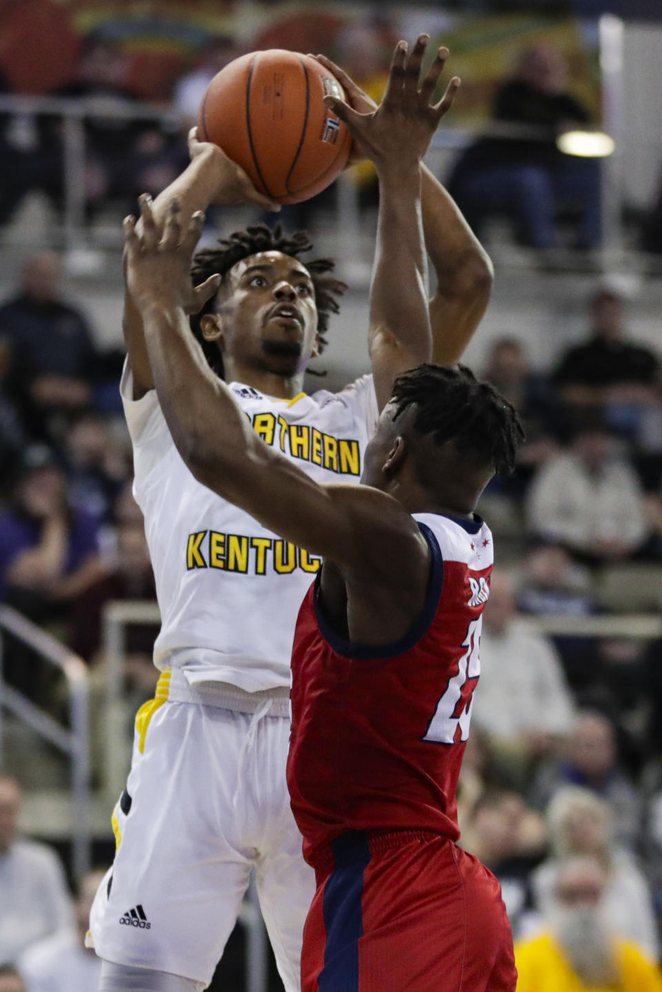 Northern Kentucky guard Jalen Tate (11) shoots over Illinois-Chicago guard Godwin Boahen (25) during the first half of an NCAA college basketball game for the Horizon League men's tournament championship in Indianapolis, Tuesday, March 10, 2020. (AP Photo/Michael Conroy)