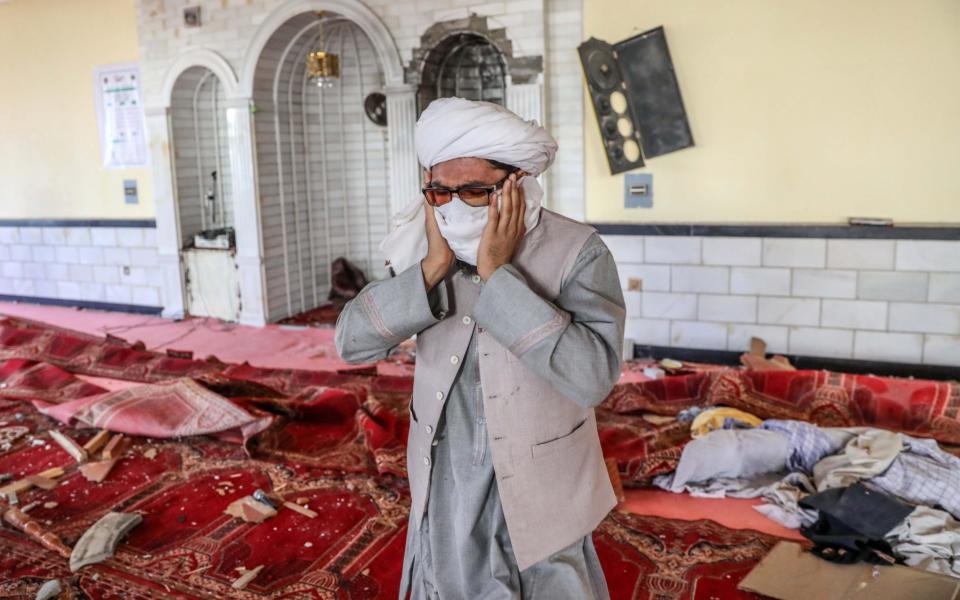 A worshipper reacts to the scene inside the mosque, where a bomb went off just as prayers began - HEDAYATULLAH AMID/EPA-EFE/Shutterstock 