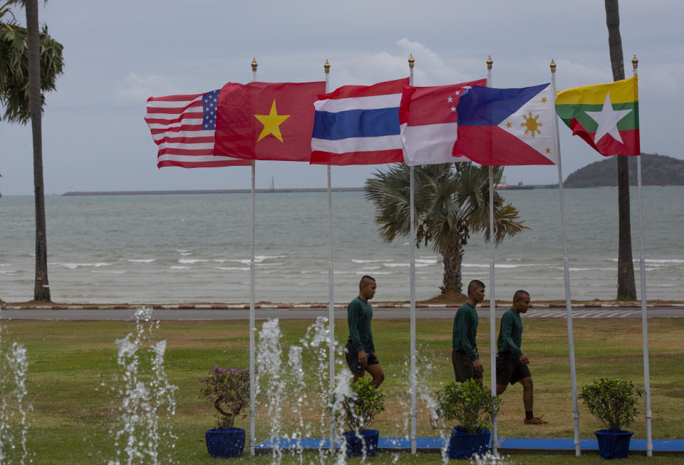 Royal Thai sailors walk past national flags of the U.S and East Asian nations hoisted for the inauguration ceremony of Association of Southeast Asian Nations, ASEAN-U.S. Maritime Exercise in Sattahip, Thailand, Monday, Sep. 2, 2019. (AP Photo/Gemunu Amarasinghe)