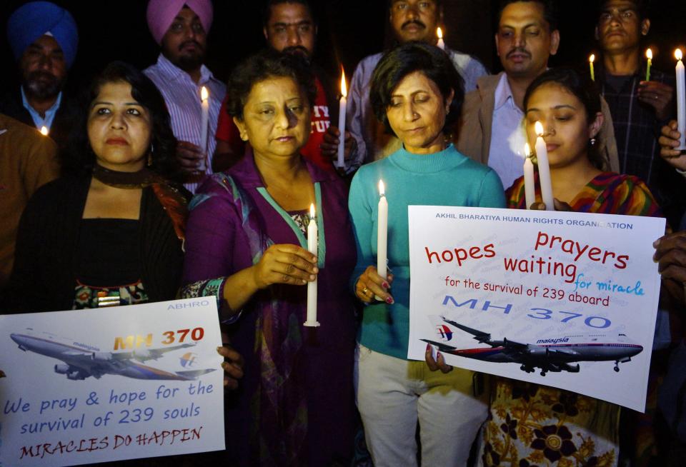 Members of Akhil Bharatiya Human Rights Organisation hold candles and placards as they take part in a candle light vigil for the well-being of passengers onboard missing Malaysia Airlines Flight MH370, in Amritsar