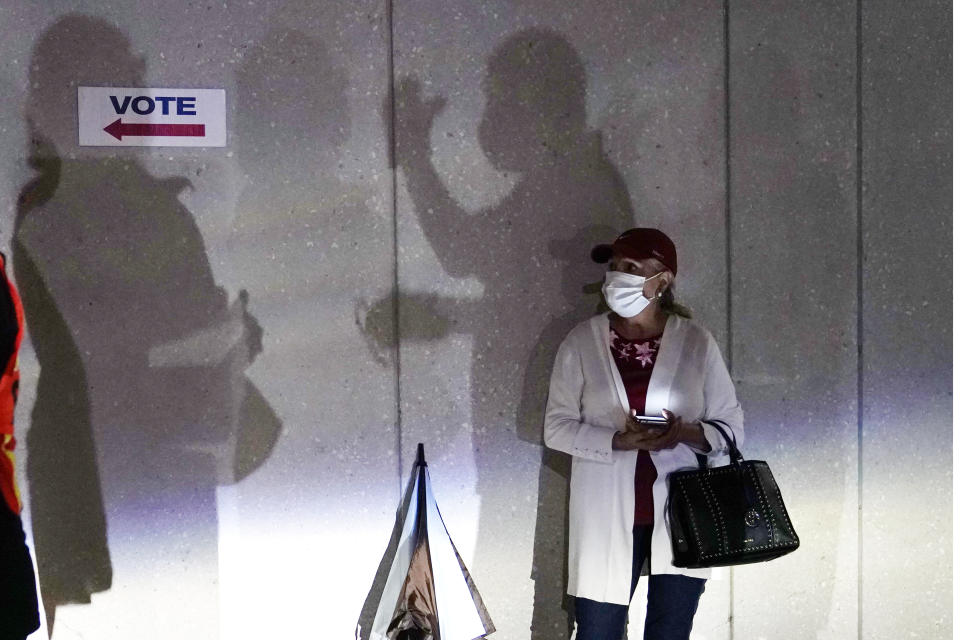 A woman waits to vote, Monday, Oct. 19, 2020, in Miami. Florida begins in-person early voting in much of the state Monday. With its 29 electoral votes, Florida is crucial to both candidates in order to win the White House. (AP Photo/Lynne Sladky)