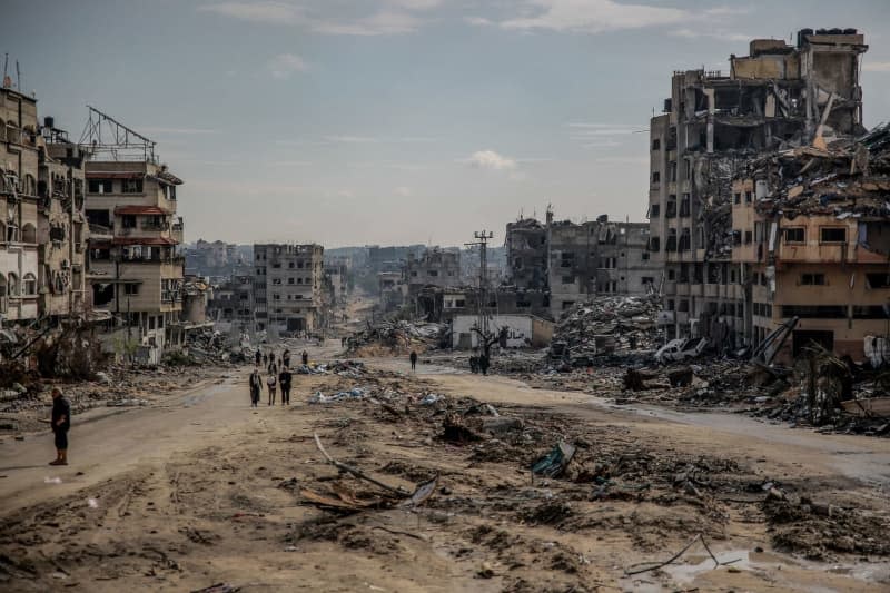 Palestinians walk across the remains of the destroyed Sheikh Radwan neighbourhood in Gaza City, after one hundred days of the Isarel-Hamas war. Omar Ishaq/dpa