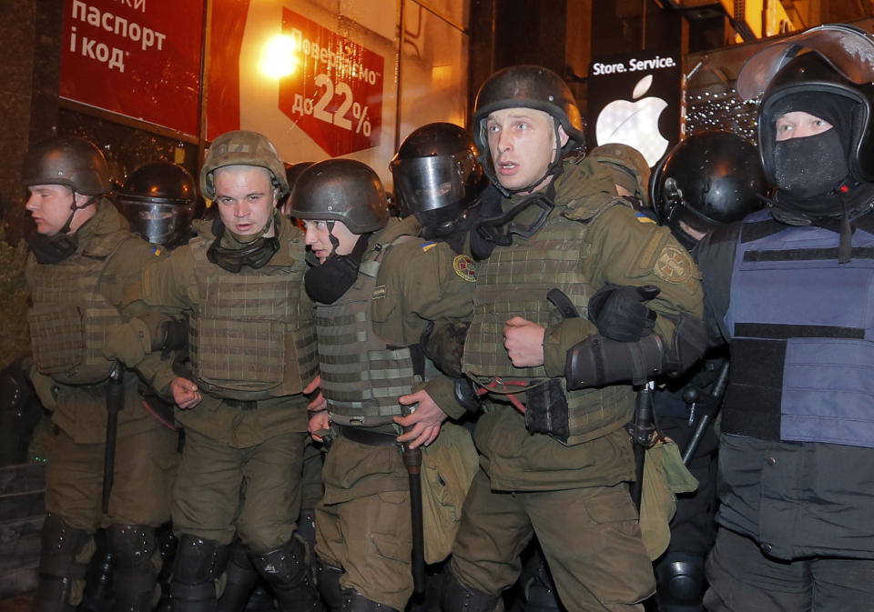 Riot police stand block protesters from reaching the front of an Alfa bank office in central Kiev, Ukraine, Tuesday, March 14, 2017. Activists and supporters of Ukrainian nationalist groups are demanding the closure of all banks associated with Russia in Ukraine. (AP Photo/Efrem Lukatsky)