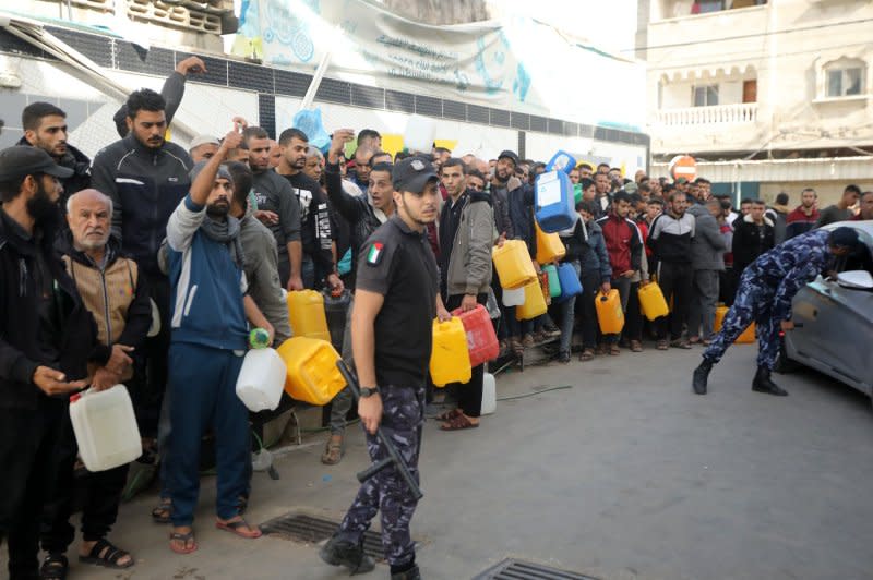 Palestinians queue with jerry cans at a petrol station in Rafah, southern Gaza, on Sunday after the arrival of 150 trucks of aid supplies to the Gaza Strip for the first time in 49 days. Aid arrived as part of the humanitarian pause for prisoner exchanges. Photo by Ismael Muhammad/UPI