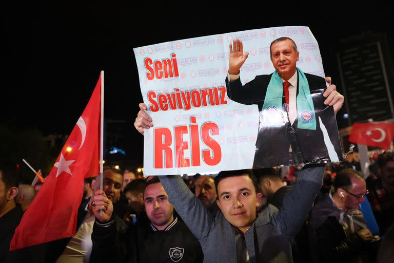 Un partidario del presidente turco Tayyip Erdogan sostiene un cartel que dice "Te amamos, jefe" fuera de la sede del Partido AK después del cierre de las urnas en las elecciones presidenciales y parlamentarias de Turquía en Ankara, Turquía, el 15 de mayo de 2023