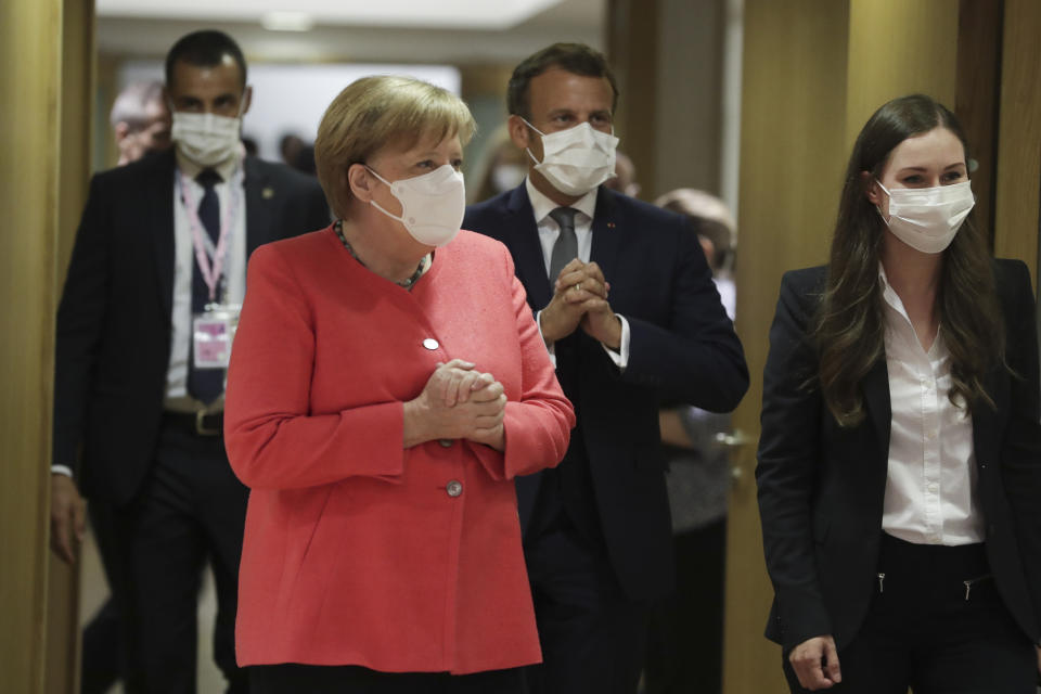 From left, German Chancellor Angela Merkel, French President Emmanuel Macron and Finland's Prime Minister Sanna Marin arrive for a round table meeting at an EU summit in Brussels, Friday, July 17, 2020. Leaders from 27 European Union nations meet face-to-face on Friday for the first time since February, despite the dangers of the coronavirus pandemic, to assess an overall budget and recovery package spread over seven years estimated at some 1.75 trillion to 1.85 trillion euros. (Stephanie Lecocq, Pool Photo via AP)