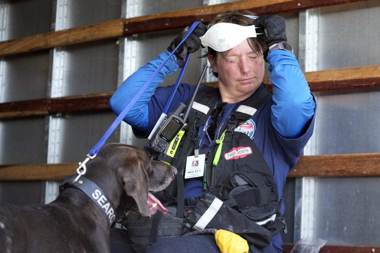 A member of a search-and-rescue team and her cadaver dog cool off near Front Street, Saturday, Aug. 12, 2023, in Lahaina, Hawaii, following heavy damage caused by wildfires. (AP Photo/Rick Bowmer)
