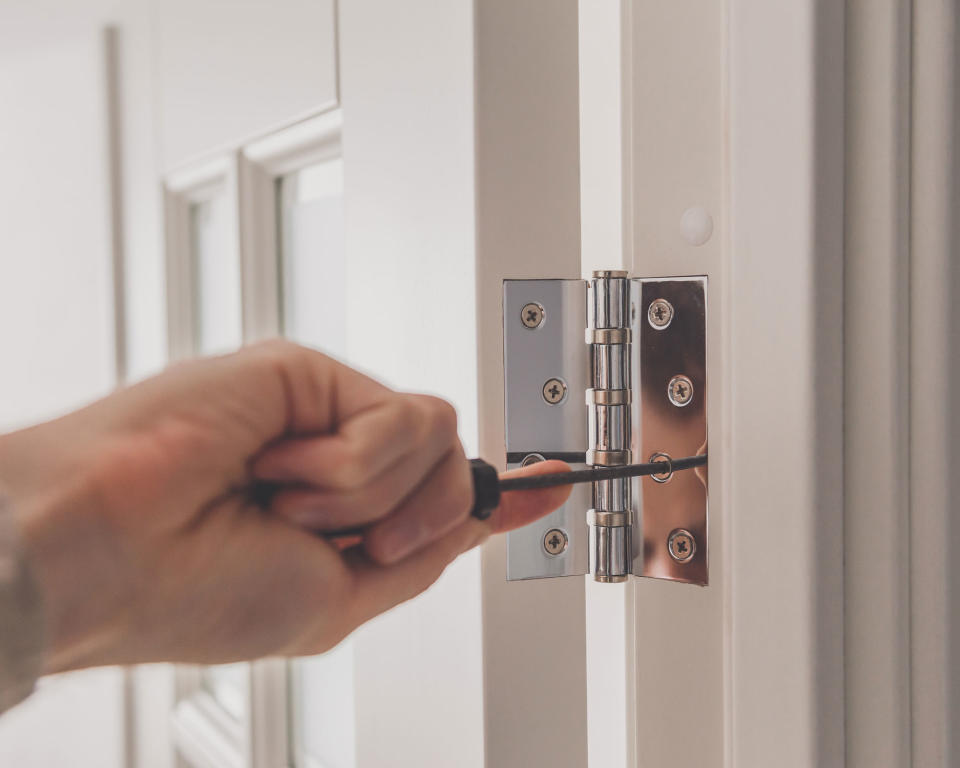 Stainless steel door hinges on a white door