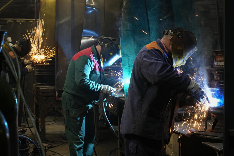 Volunteers weld a heating stove from old car rims in workshop in Siauliai, some 230 km (144 miles) north-west of the capital Vilnius, Lithuania, Thursday, Feb. 2, 2023. Since Russia invaded Ukraine last February, Lithuania, Latvia and Estonia — three states on NATO’s eastern flank scarred by decades of Soviet-era occupation — have been among the top donors to Kyiv. (AP Photo/Sergei Grits)