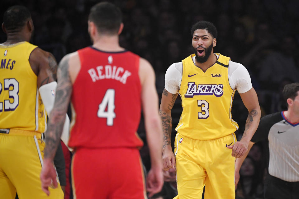 Los Angeles Lakers forward Anthony Davis, right, celebrates with forward LeBron James after dunking as New Orleans Pelicans guard JJ Redick looks away during the first half of an NBA basketball game Friday, Jan. 3, 2020, in Los Angeles. (AP Photo/Mark J. Terrill)