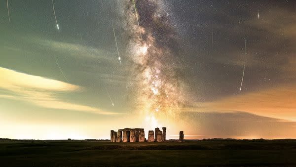     Unter einem Sternenhimmel mit Sternschnuppen ist die Silhouette von Stonehenge zu sehen. 