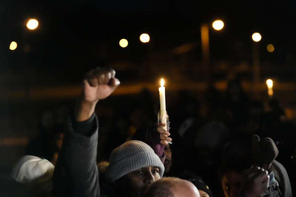 People hold up candles and fists at a candlelight vigil for Tyre Nichols, who died after being beaten by Memphis police officers, in Memphis, Tenn., Thursday, Jan. 26, 2023. (AP Photo/Gerald Herbert)