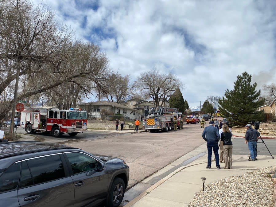 News crews and onlookers observe the fire