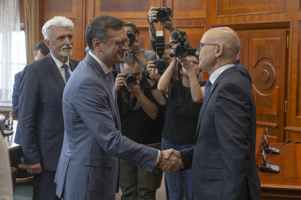 Serbian Prime Minsiter Milos Vucevic, front right, shakes hands with Ukraine's Foreign Minister Dmytro Kuleba, front left, in Belgrade, Serbia, Monday, May 13, 2024. Kuleba, who has arrived on a surprise visit to Russia-friendly Serbia, held talks on Monday in Belgrade in a sign of warming relations between the two states. (AP Photo/Marko Drobnjakovic)