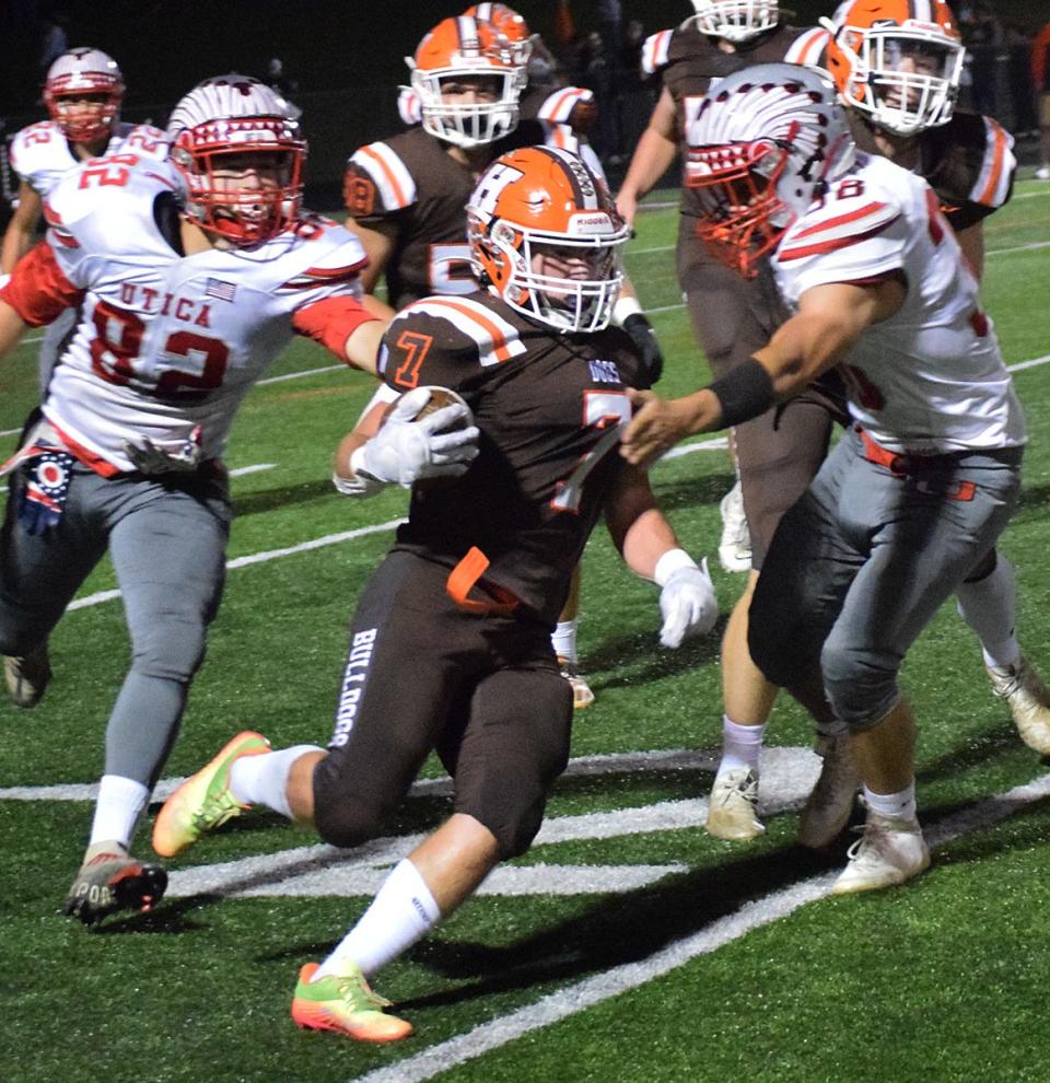 Heath sophomore Connor Corbett gets the edge against Utica seniors Zachery Cyphers (38) and Jordan Hartman (82) at Swank Field on Friday, Sept. 30, 2022. The host Bulldogs celebrated Homecoming with a 40-0 victory.