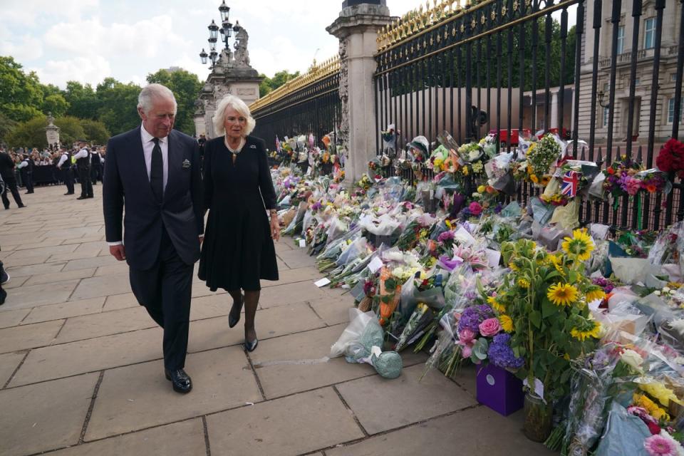 The King and Queen view tributes left outside Buckingham Palace (Yui Mok/PA) (PA Wire)