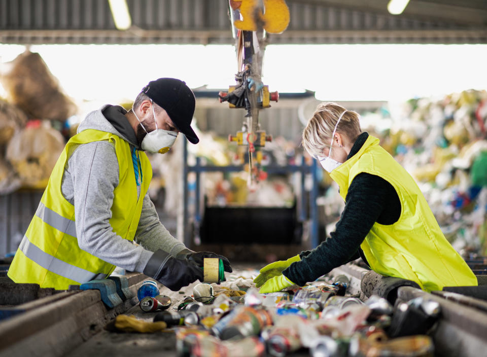 Two people separate waste for recycling. (Getty Images)