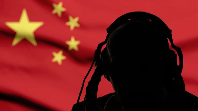 Silhouette of a man in headphones, secret agent eavesdropping, spy and scout, China flag, backlight