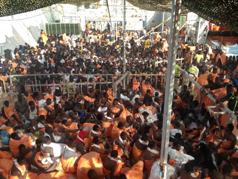 Migrants wait to disembark from the Siem Pilot ship on October 24, 2016 in Palermo after rescue operations of migrants at see during the week-end